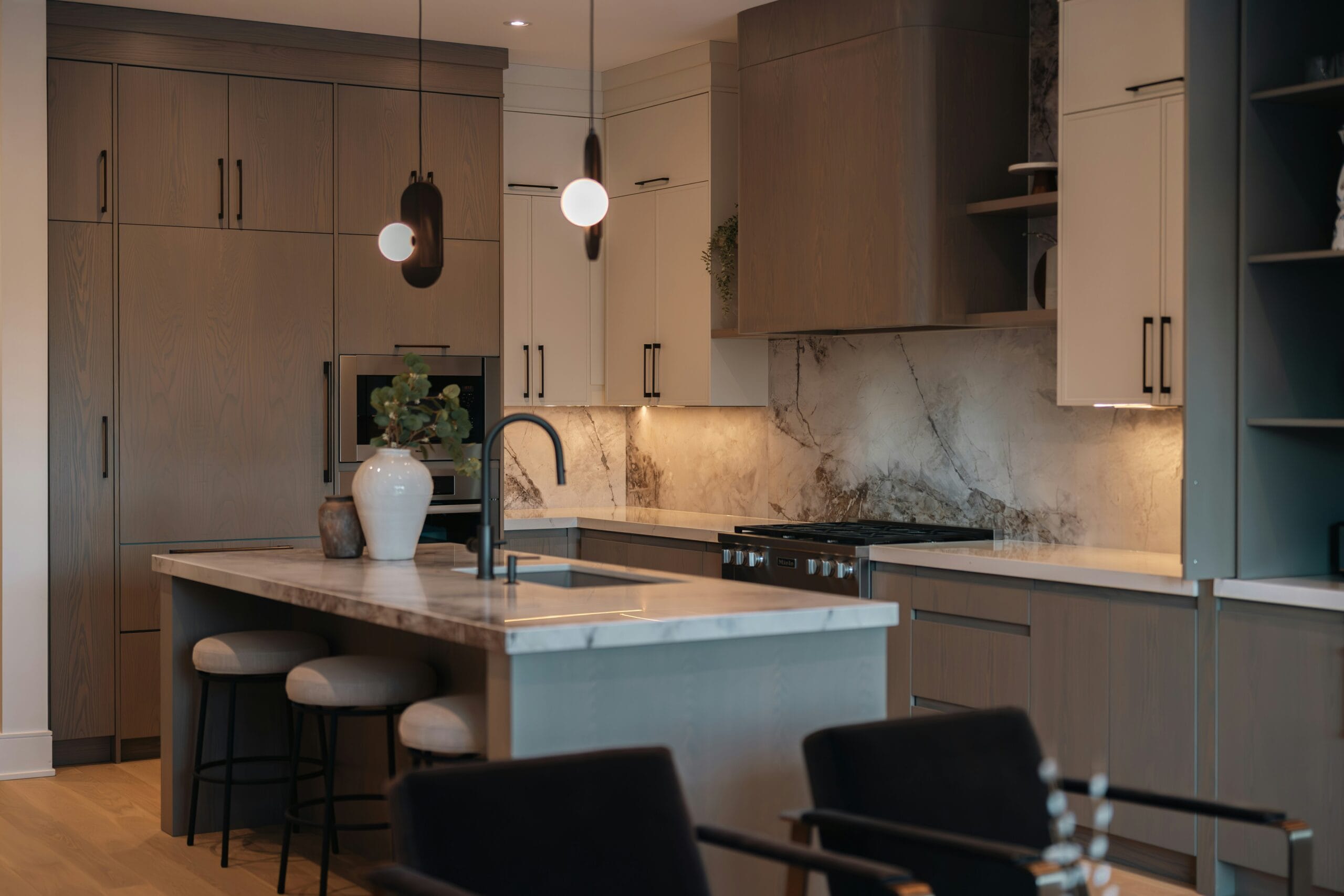 Dramatic veined stone slab countertop and backsplash in a luxury Portland kitchen